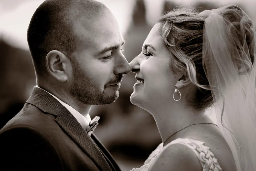 Photo de mariage en noir et blanc en Seine-et-Marne : les mariés souriants, front contre front