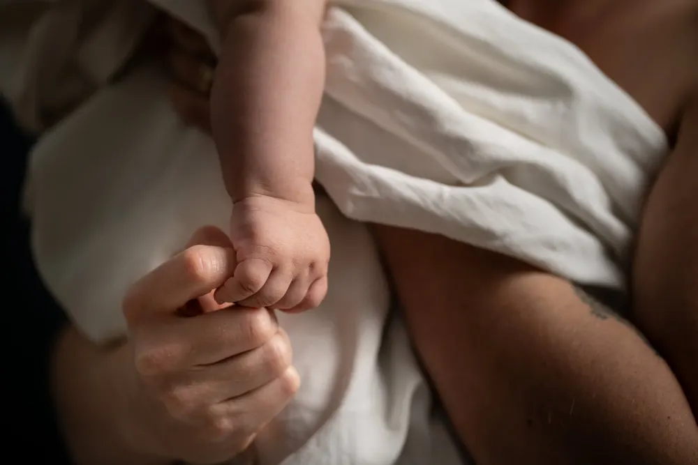 Shooting photo grossesse à Salins (77) : main d'un adulte tenant celle d'un bébé