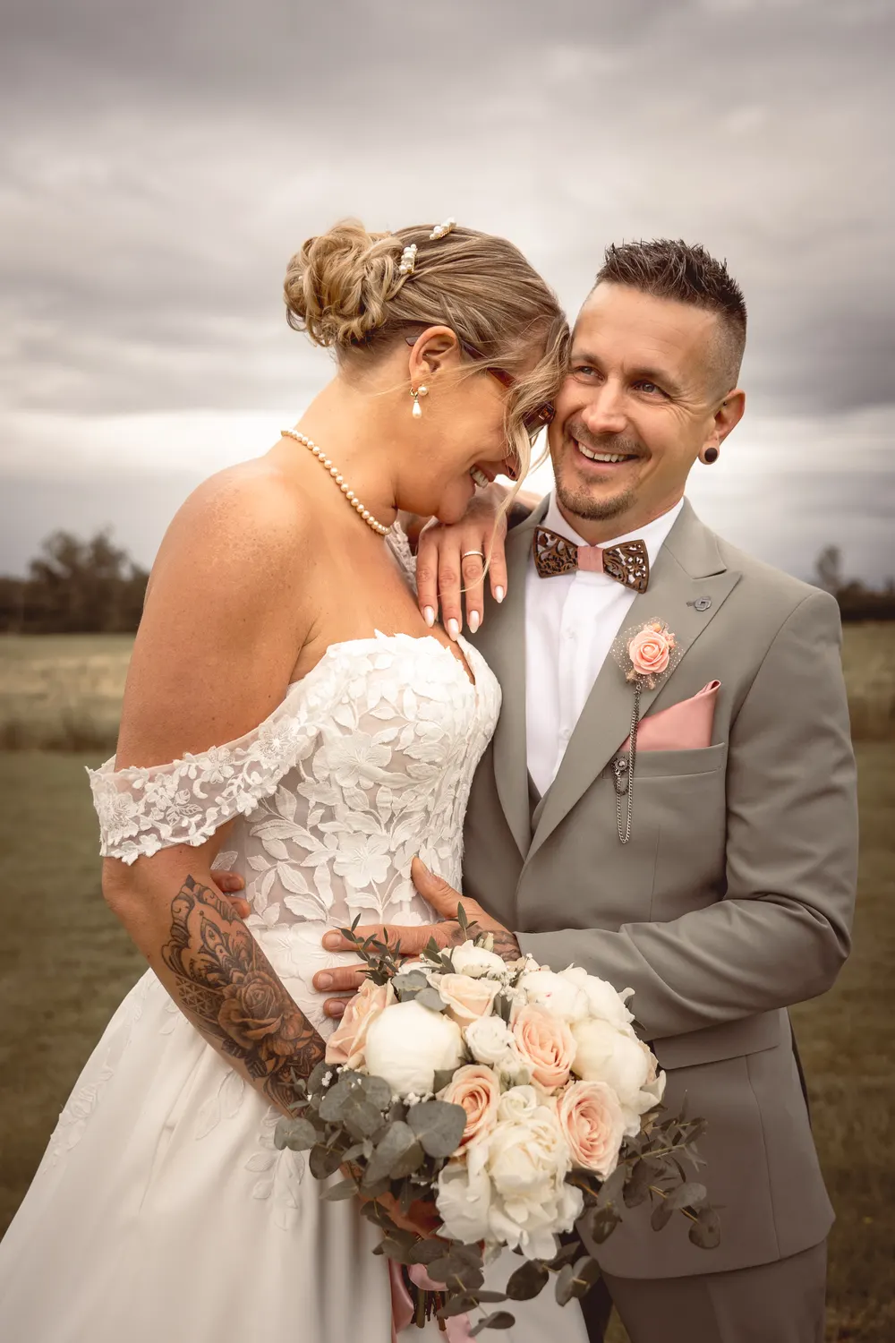 Photographe mariage en Seine-et-Marne : éclat de rire complice des mariés, la mariée appuyée contre l'épaule du marié