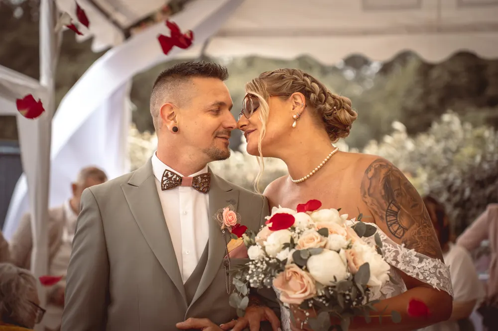 Reportage photo de mariage en Seine-et-Marne : sortie de cérémonie sous une pluie de pétales rouges