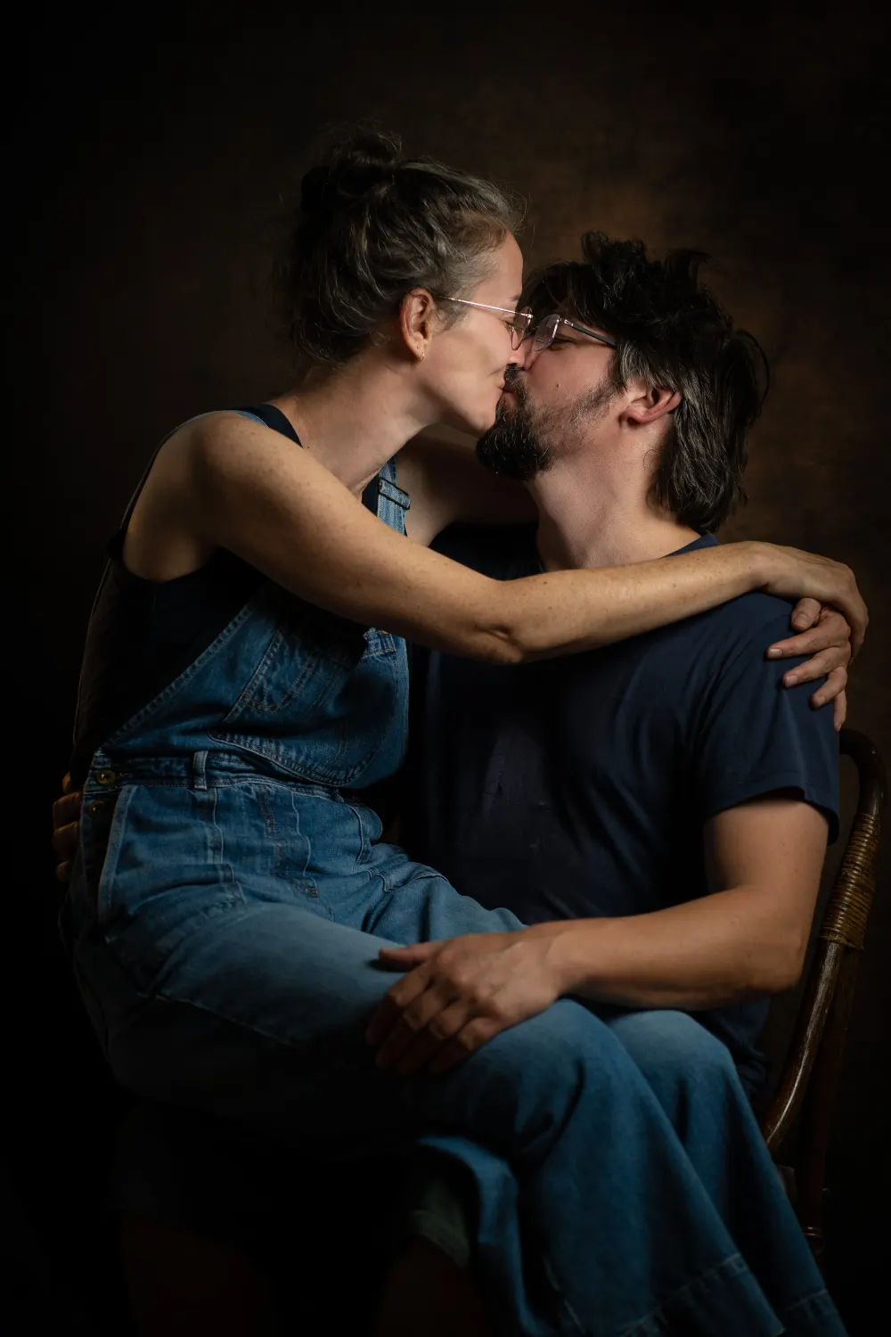 Photographe couple à Salins (77) : un couple s'embrasse tendrement sur fond sombre