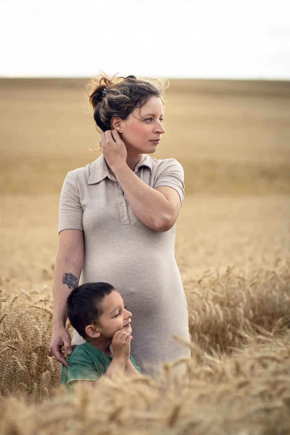 Shooting photo famille en extérieur près de Salins (77) : une mère et deux enfants dans un champ de blé, regardant au loin